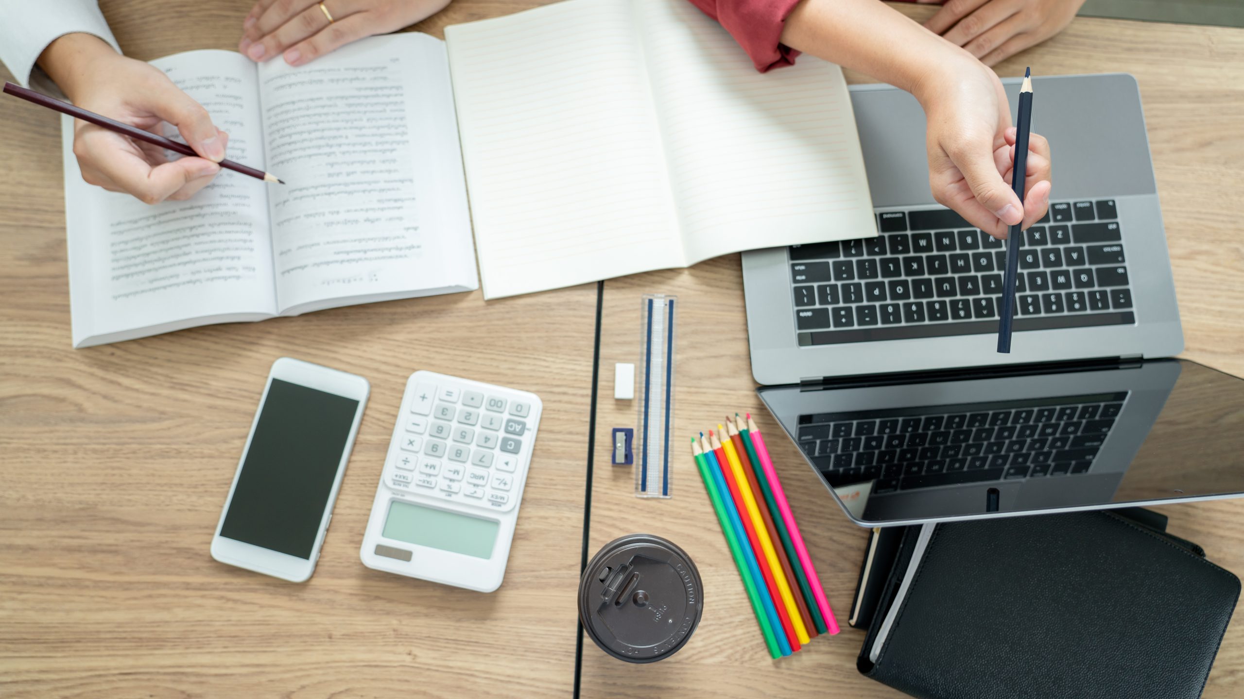 Teaching helping technology concept. Woman young teacher or tutor with adult students in classroom at desk with papers, laptop computer. Studies course.